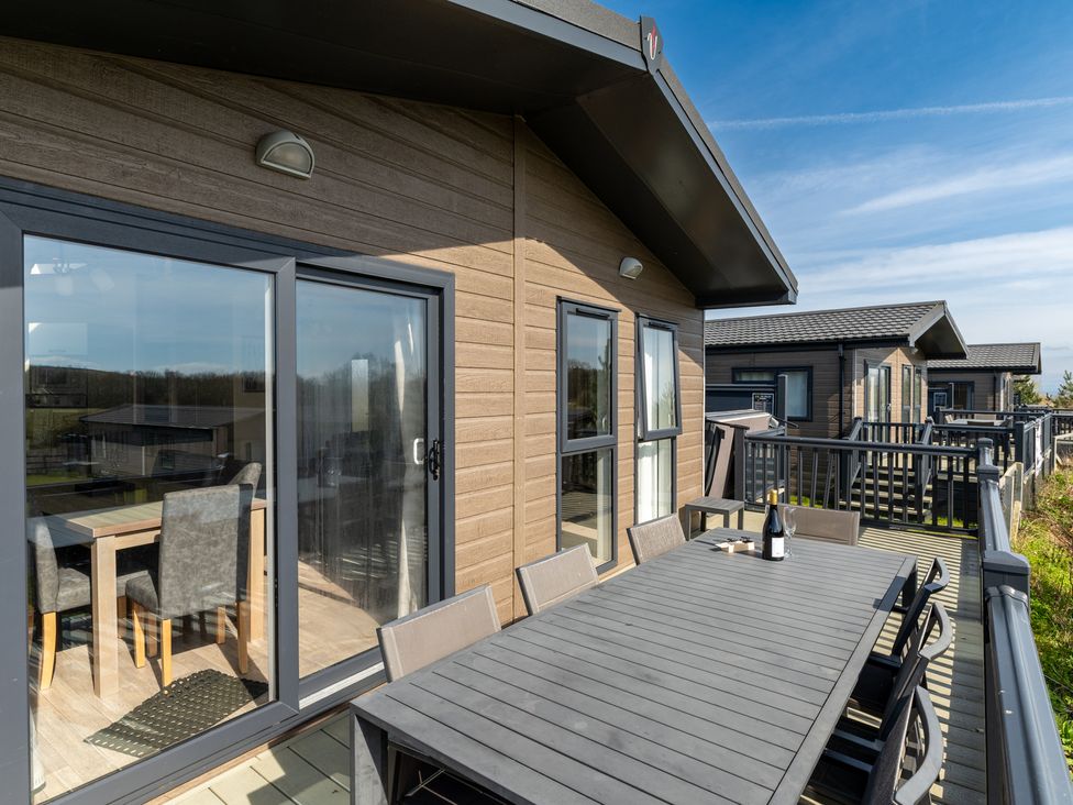 A deck with a dining table and chairs at Scaféll in Penrith