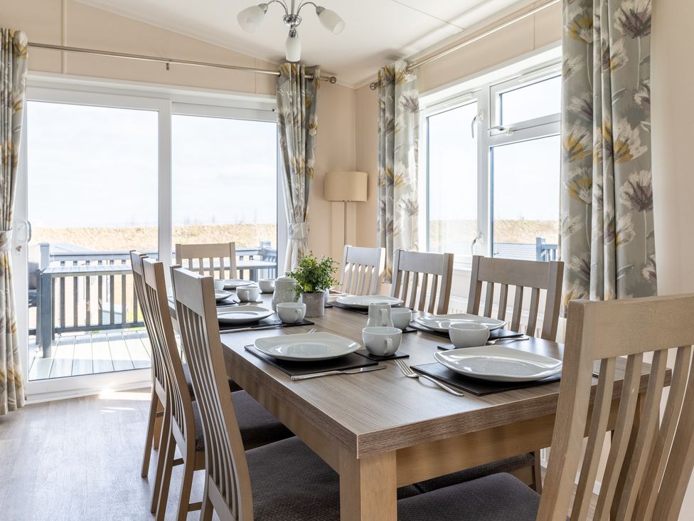 A dining room with a table set for meals at Scaféll in Penrith