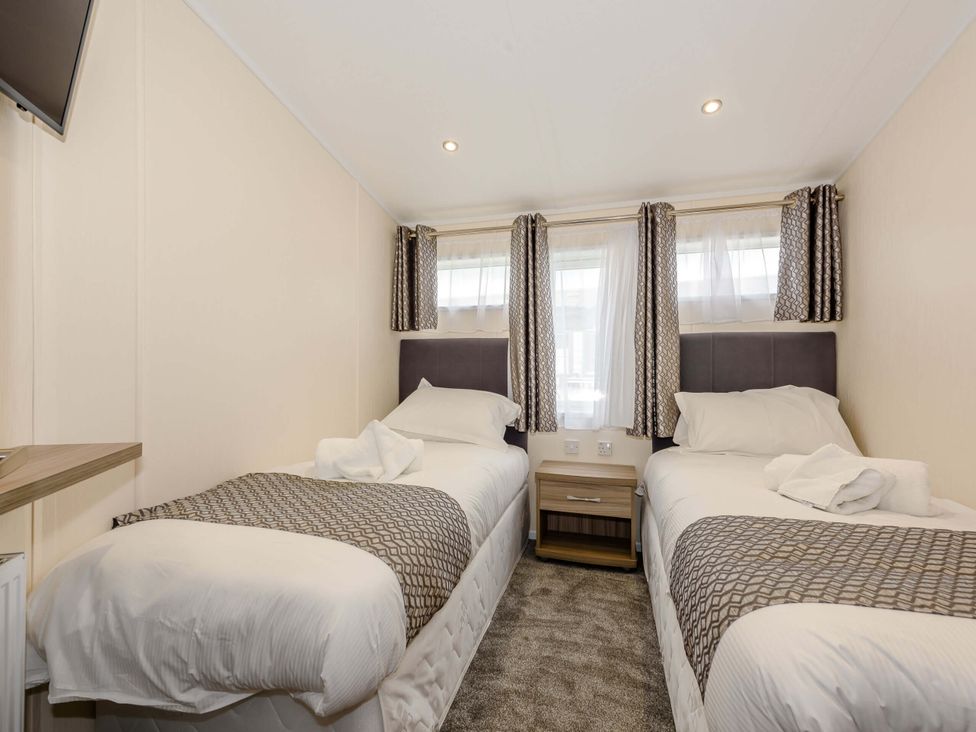 A bedroom with two beds and a nightstand at Scaféll in Penrith