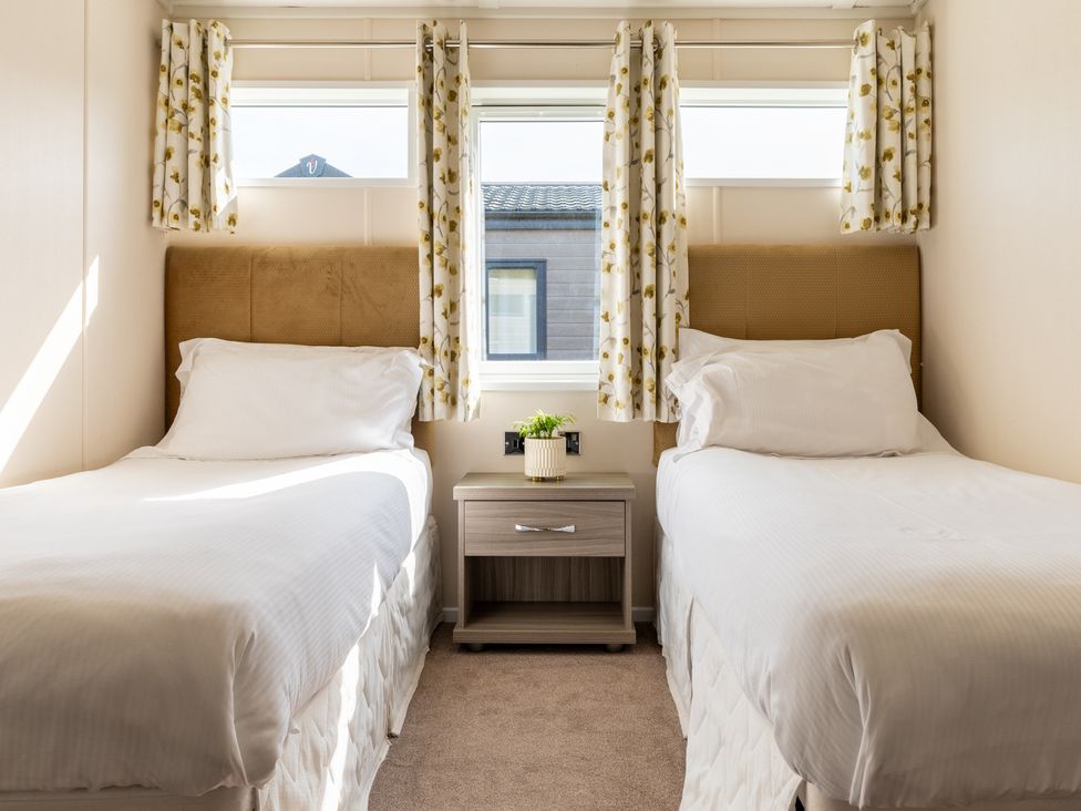 A bedroom with two single beds and a bedside table at Scaféll (Pet) Penrith