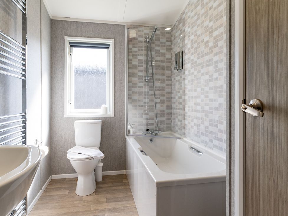 A bathroom with a bathtub and toilet at Scaféll (Pet) Penrith
