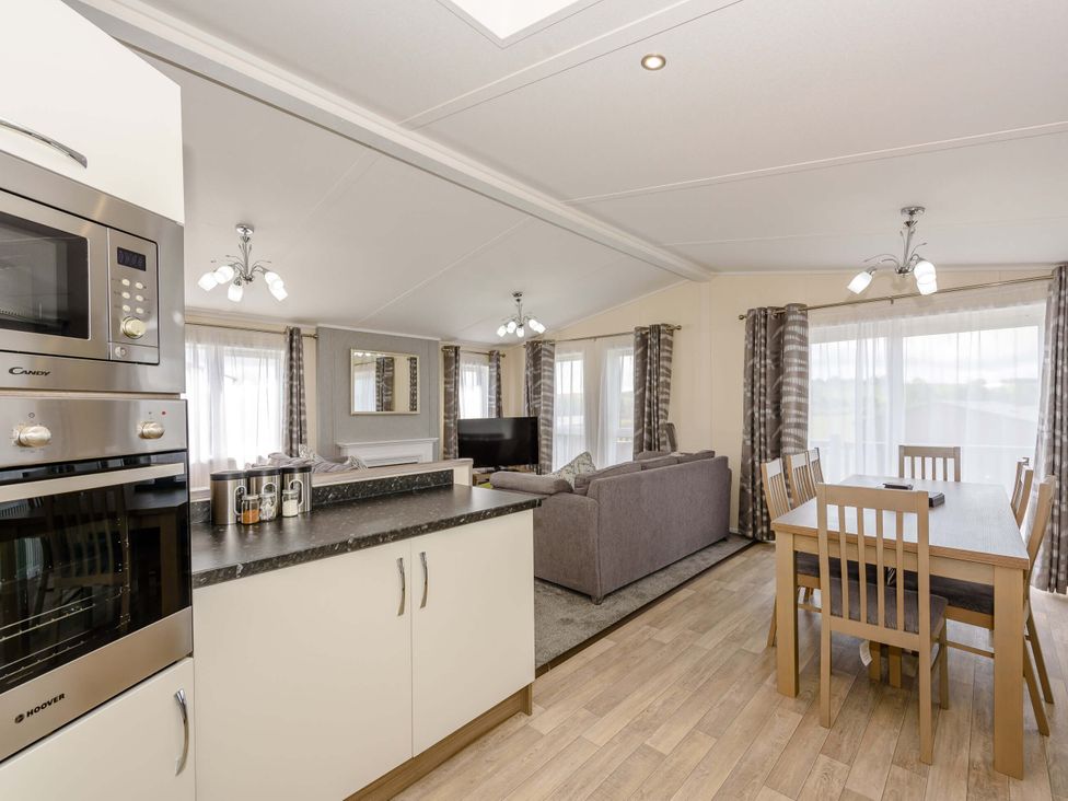 A living room with a dining area and kitchen appliances at Scaféll (Pet) Penrith