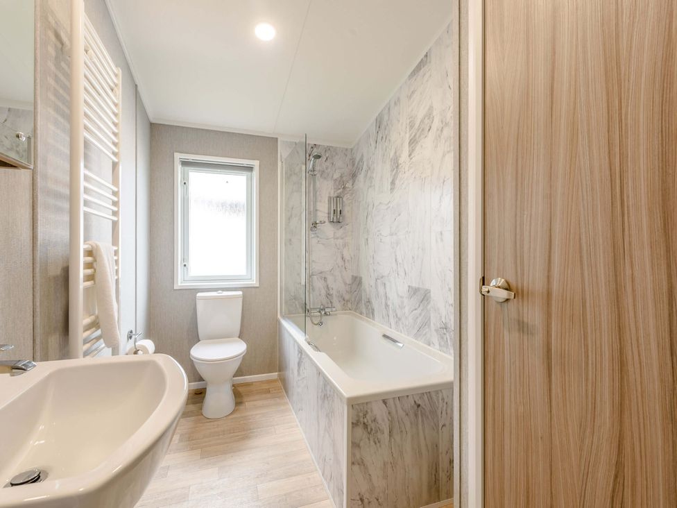 A bathroom with a tub and sink at Scaféll (Pet) in Penrith