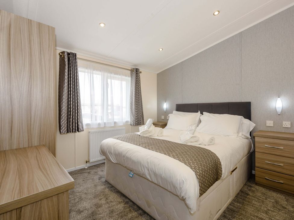 A bedroom with a bed and nightstand at Scaféll (Pet) Penrith