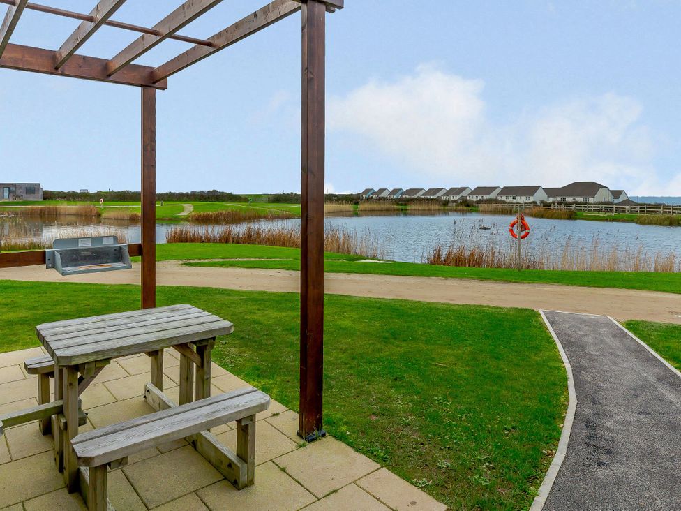 An outdoor area with a table and benches at Lakeside Studio Pet Portreath