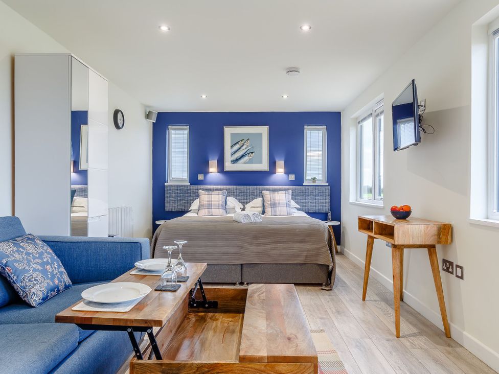 A bedroom with a bed and sofa at Lakeside Studio Pet in Portreath