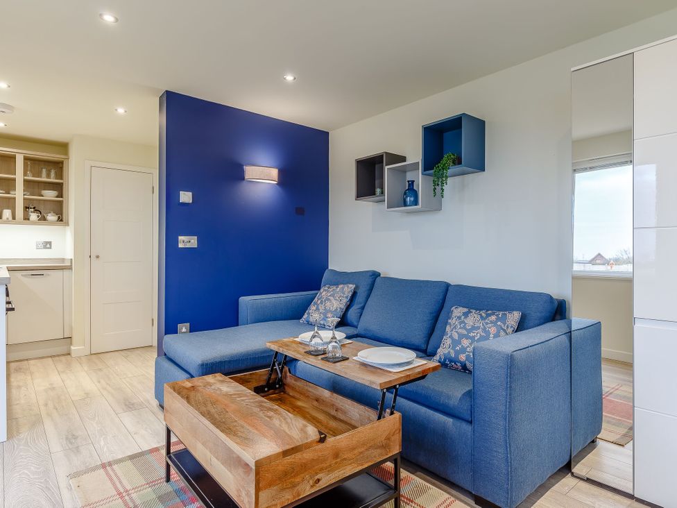 A living room with a sofa and coffee table at Lakeside Studio Pet Portreath
