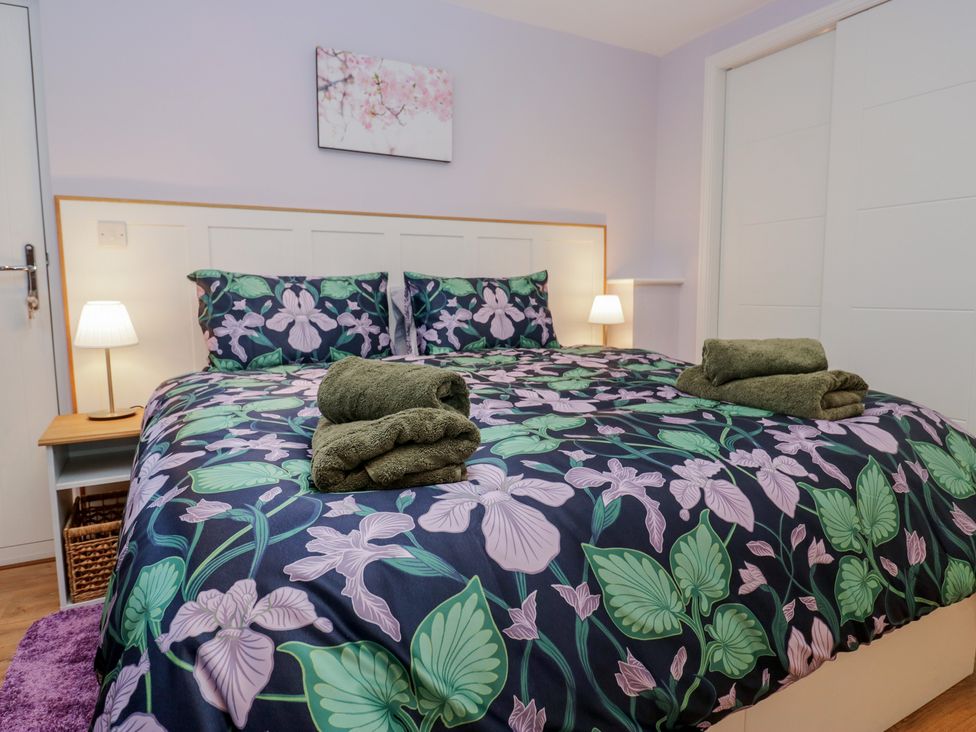 A bedroom with a bed and bedside table at Renes Shop in Grange-Over-Sands