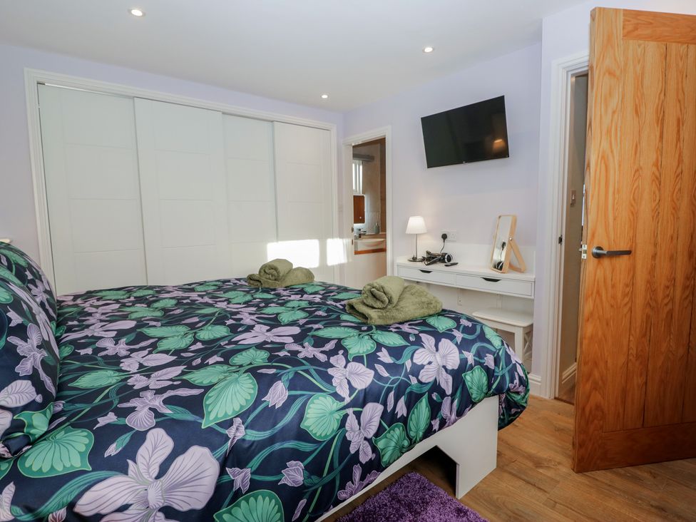 A bedroom with a bed and TV at Renes Shop in Grange-Over-Sands