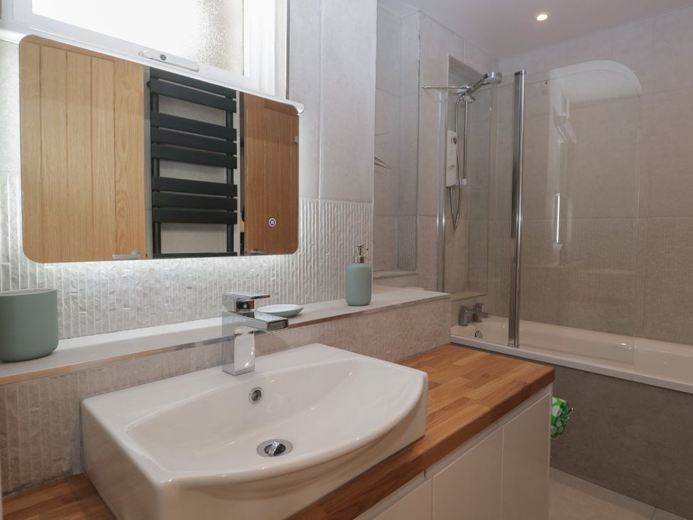 A bathroom with a sink and bathing tub at Renes Shop in Grange-Over-Sands