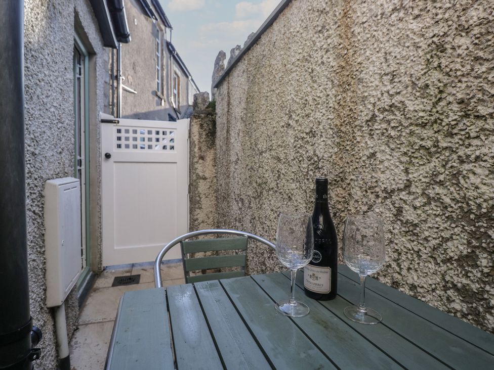 A table with wine and glasses beside a door at Renes Shop in Grange-Over-Sands