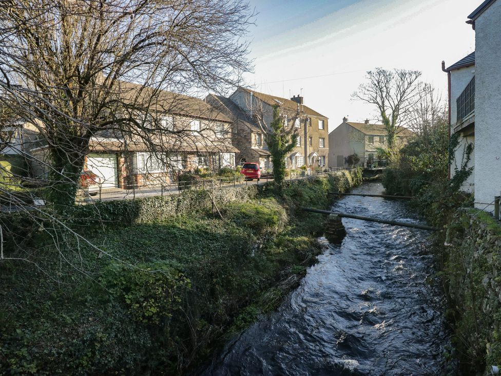 An outdoor view with houses and a stream at Renes Shop in Grange-Over-Sands