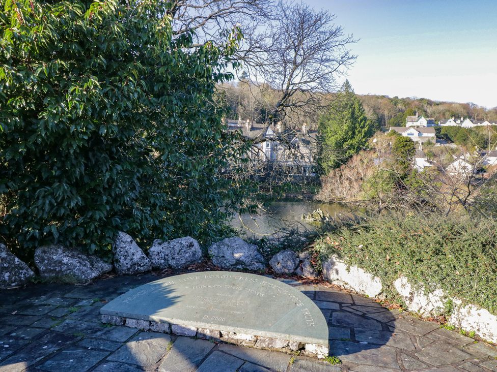 A plaque and foliage near a river at Renes Shop in Grange-Over-Sands