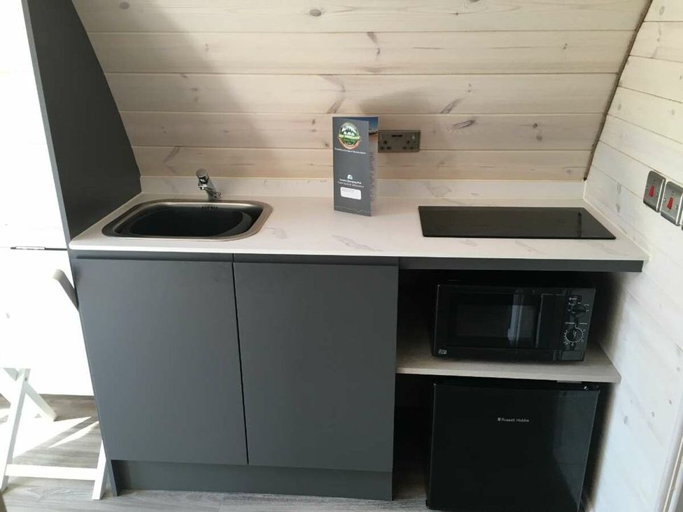 A kitchen with a sink, cooktop, microwave, and mini fridge at Pod 2 (No Pets) Carnforth