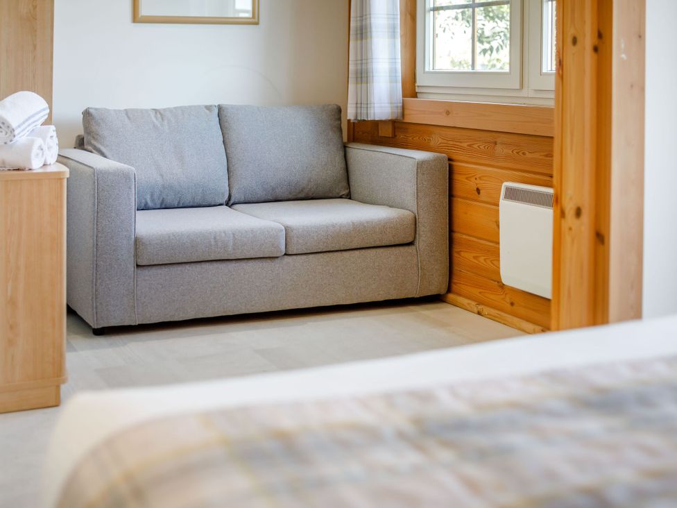 A living room with a sofa and a bedside table at Scandinavian Lodge 4 Portreath