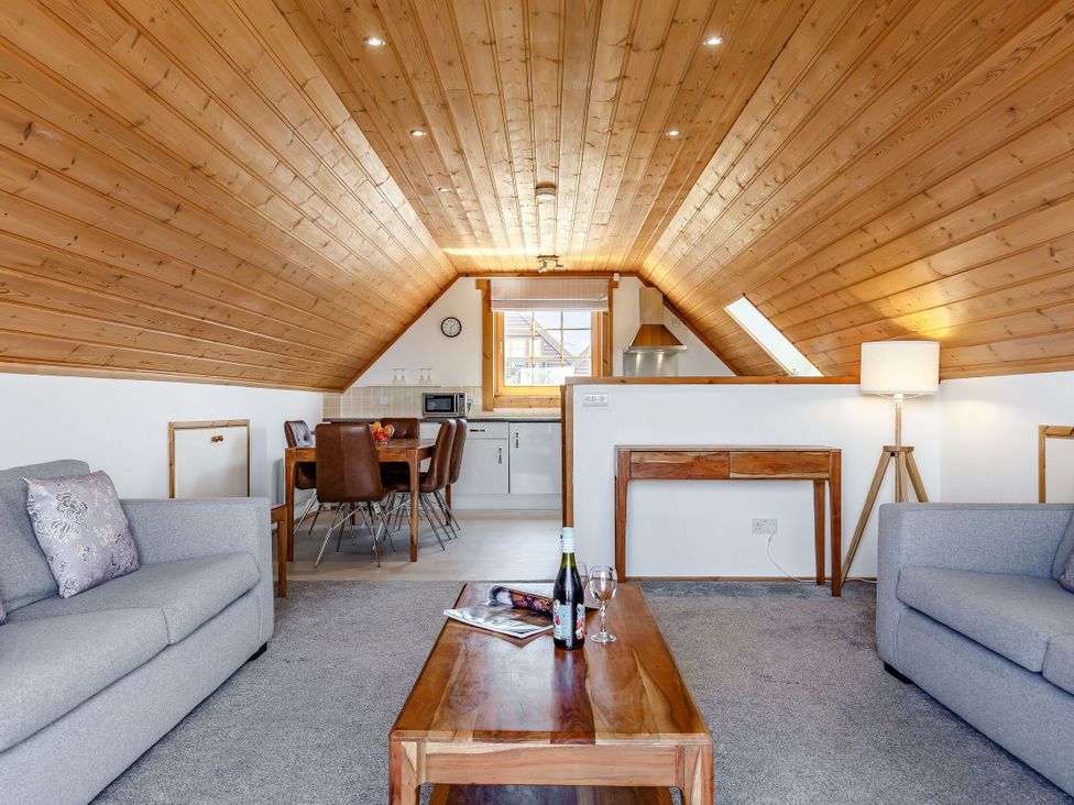 A living room with a sofa and dining area at Scandinavian Lodge 4 in Portreath
