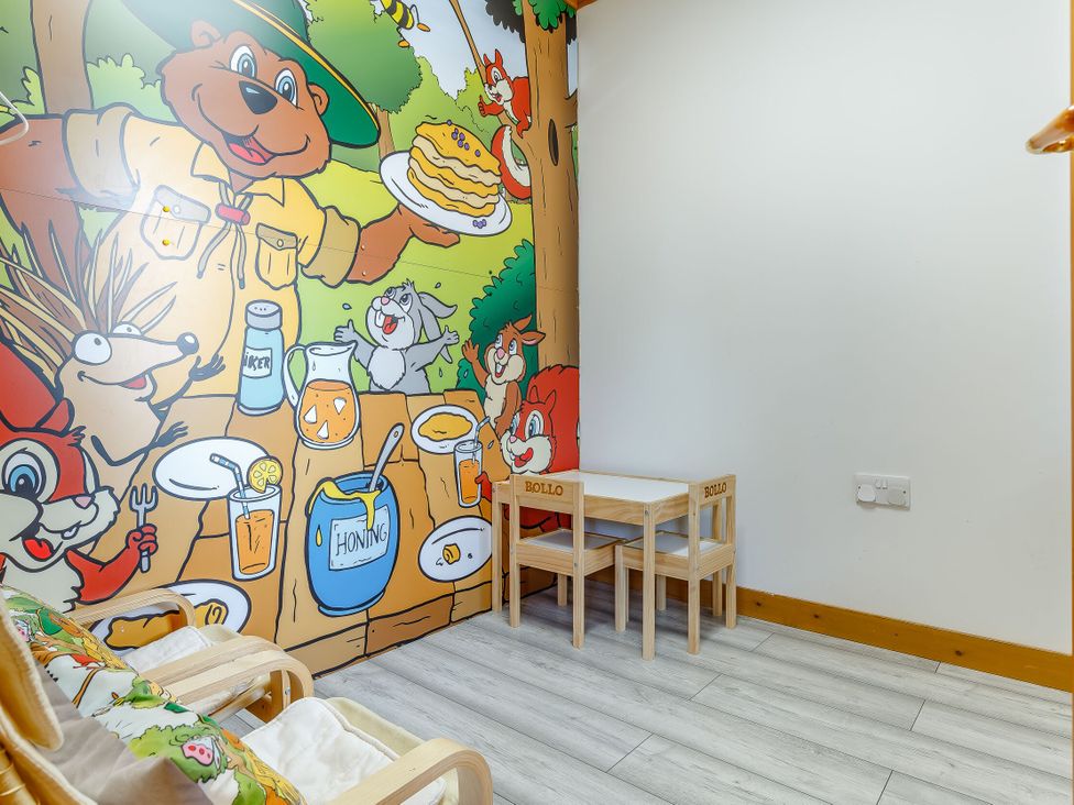 A playroom with table and chairs at Kinder Lodge in Portreath