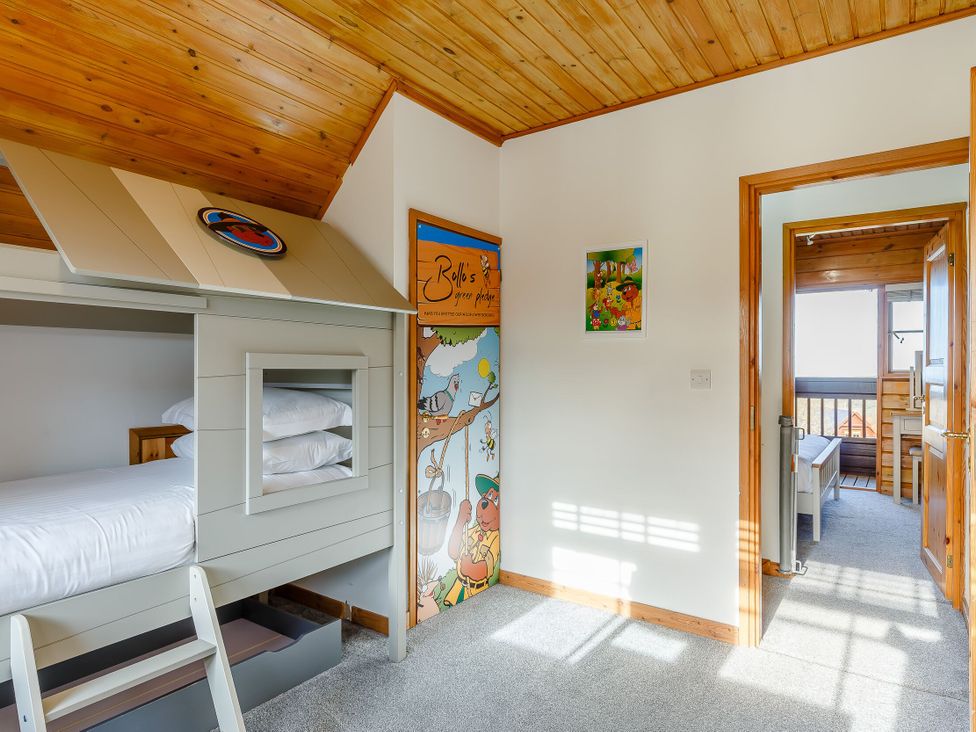 A bedroom with a bunk bed and wall art at Kinder Lodge in Portreath