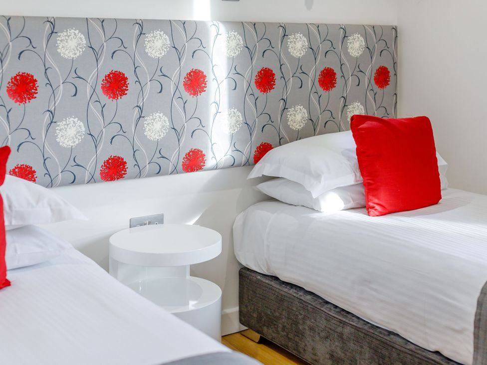 A bedroom with two beds and a decorative headboard at Signature Lodge Pet 4 Portreath
