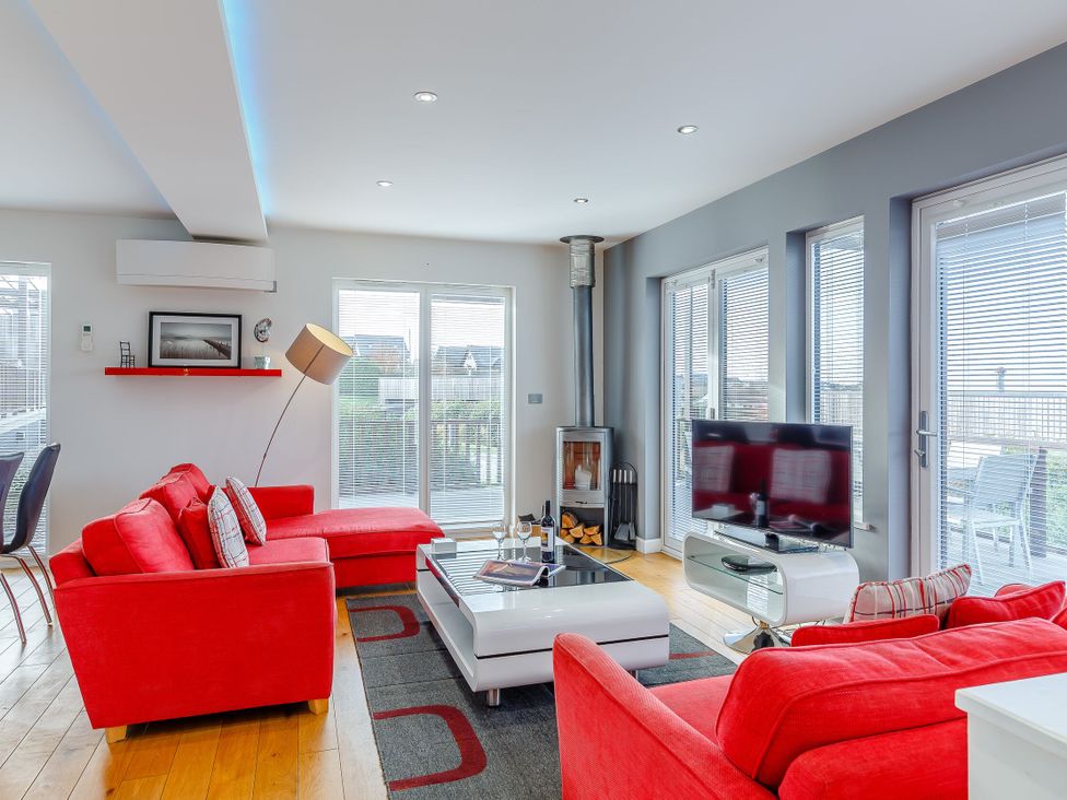 A living room with a sofa and television at Signature Lodge Pet 4 in Portreath