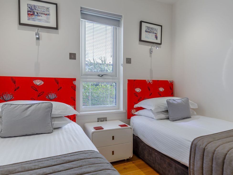 A bedroom with two beds and a window at Signature Lodge Pet 4 Portreath
