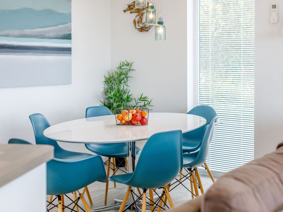 A dining area with a round table and chairs at Signature Assisted Living 5 Portreath