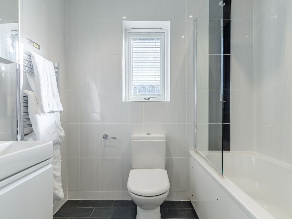 A bathroom with a toilet and bath tub at Signature Assisted Living 5 Portreath