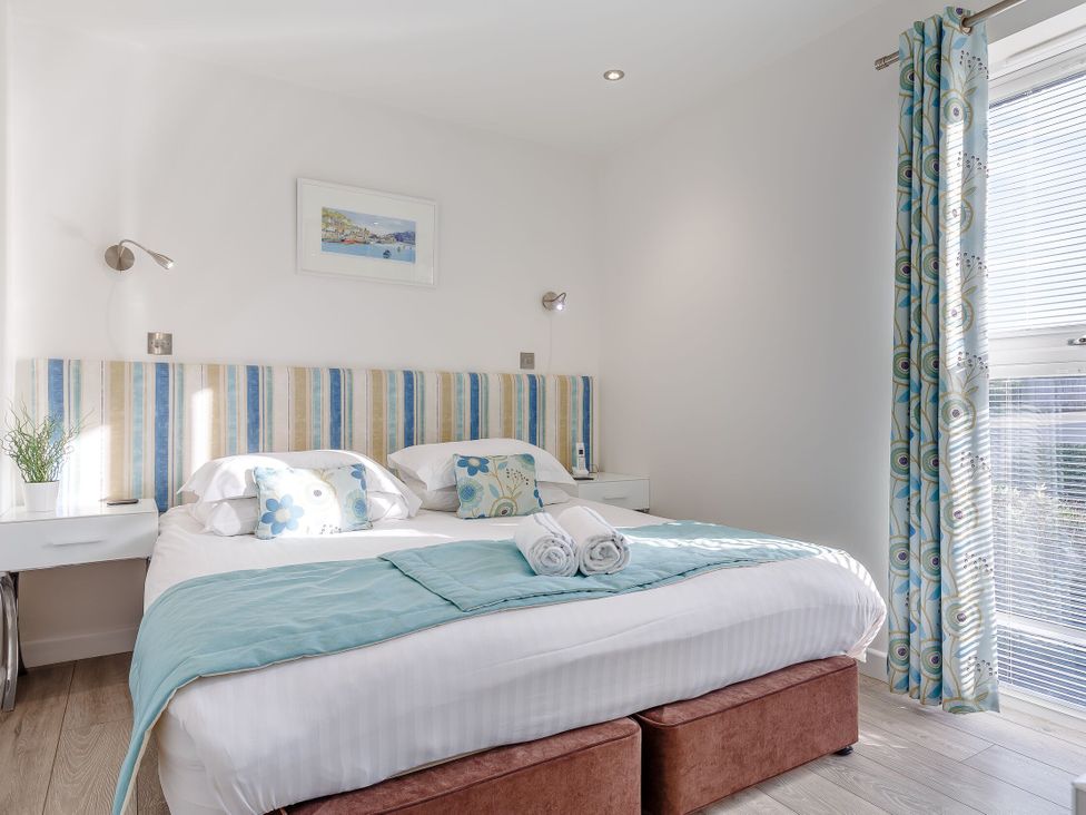 A bedroom with a bed and bedside table at Signature Assisted Living Pet in Portreath