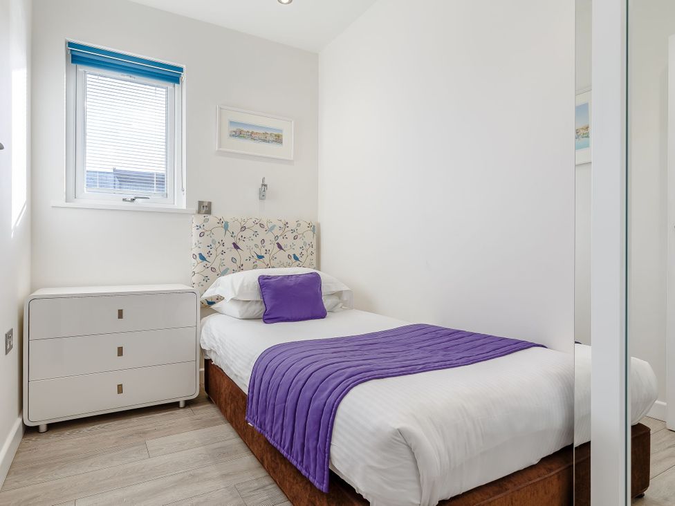 A bedroom with a single bed and dresser at Signature Assisted Living Pet in Portreath