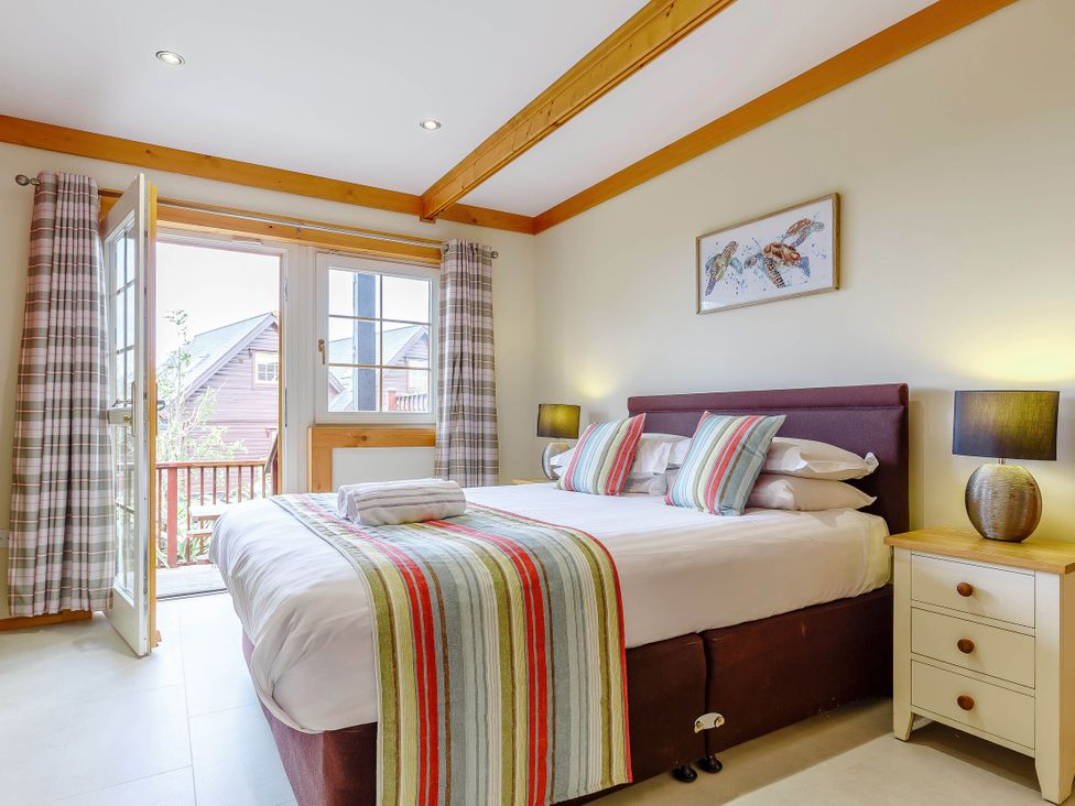 A bedroom with a bed and nightstand at Scandinavian Lodge 6 in Portreath
