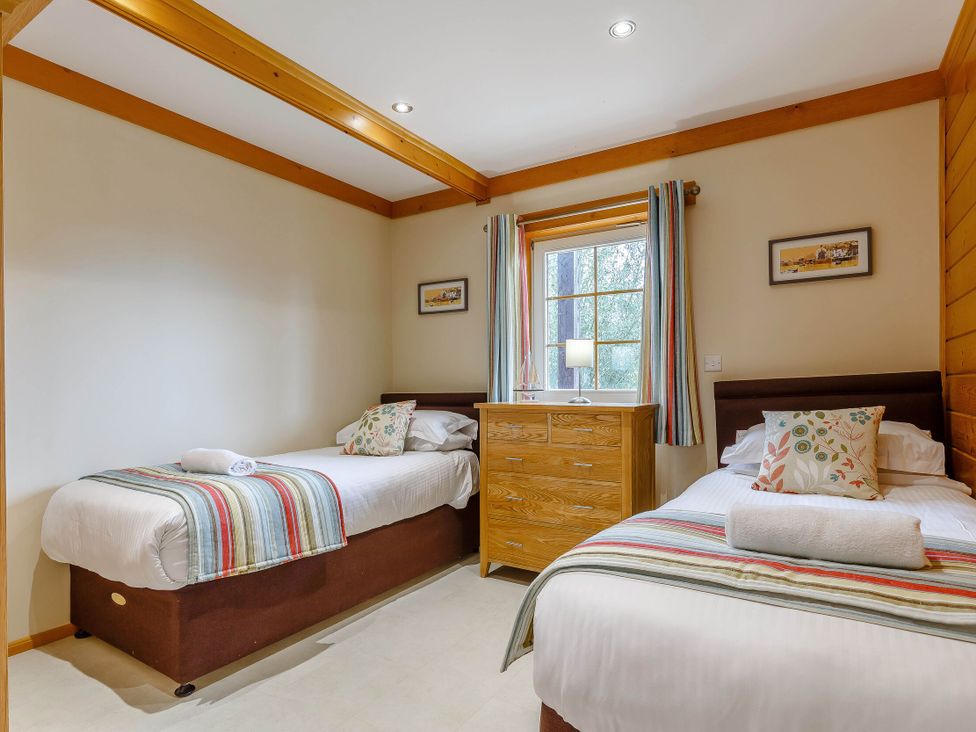 A bedroom with two beds and a dresser at Scandinavian Lodge 6 Portreath