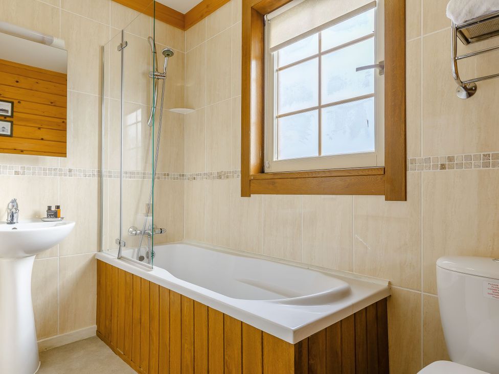 A bathroom with a bathtub, sink, and toilet at Scandinavian Hot Tub Lodge Portreath