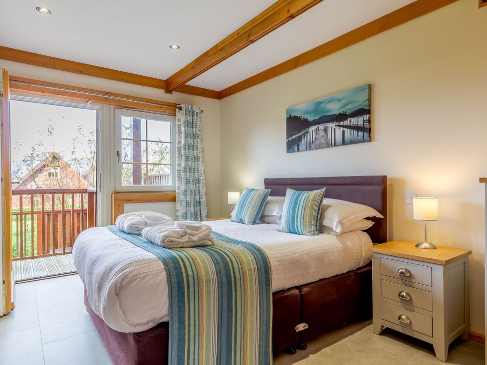 A bedroom with a bed and window at Scandinavian Hot Tub Lodge in Portreath