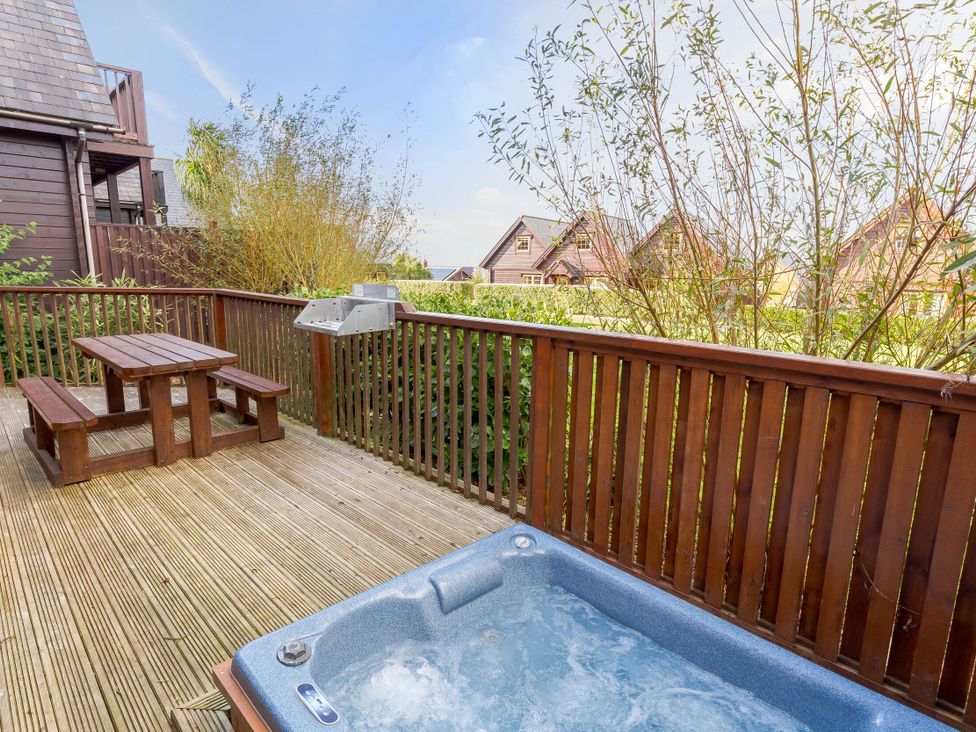An outdoor area with a hot tub and wooden seating at Scandinavian Hot Tub Lodge in Portreath