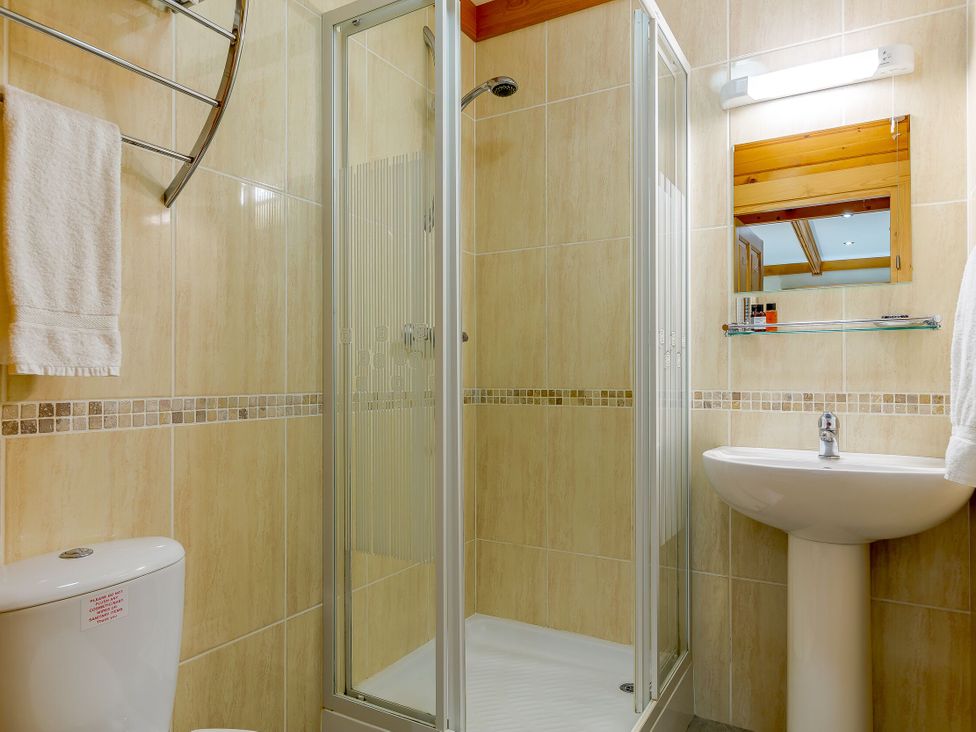 A bathroom with a shower, toilet, and sink at Scandinavian Hot Tub Lodge Pet in Portreath