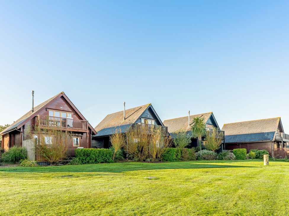 Four houses with a lawn area at Scandinavian Lodge Pet Portreath