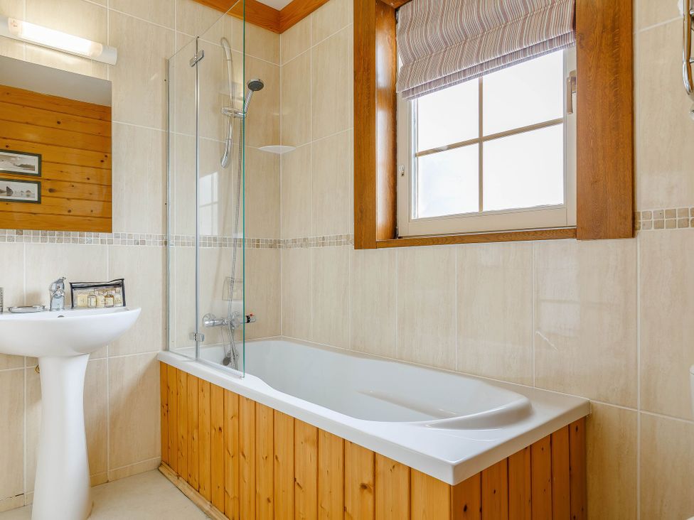 A bathroom featuring a bathtub and sink at Scandinavian Lodge Pet in Portreath