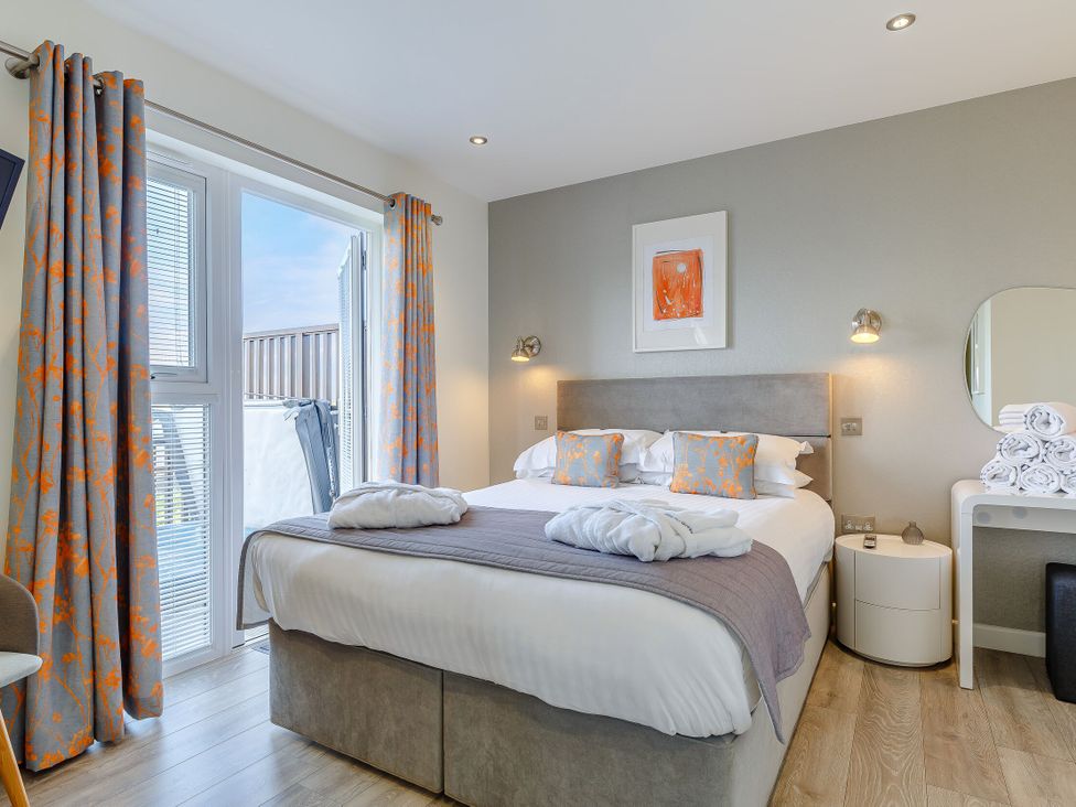 A bedroom with a bed and curtains at Signature Lodge 6 in Portreath