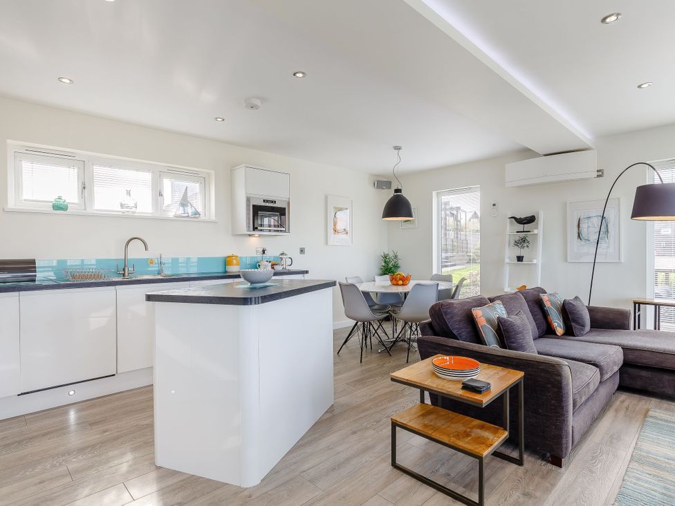 A kitchen and living room with a sofa and dining table at Signature Lodge Pet 6 Portreath