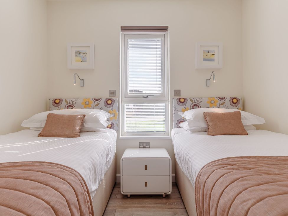 A bedroom with two beds and a window at Signature Lodge Pet 6, Portreath