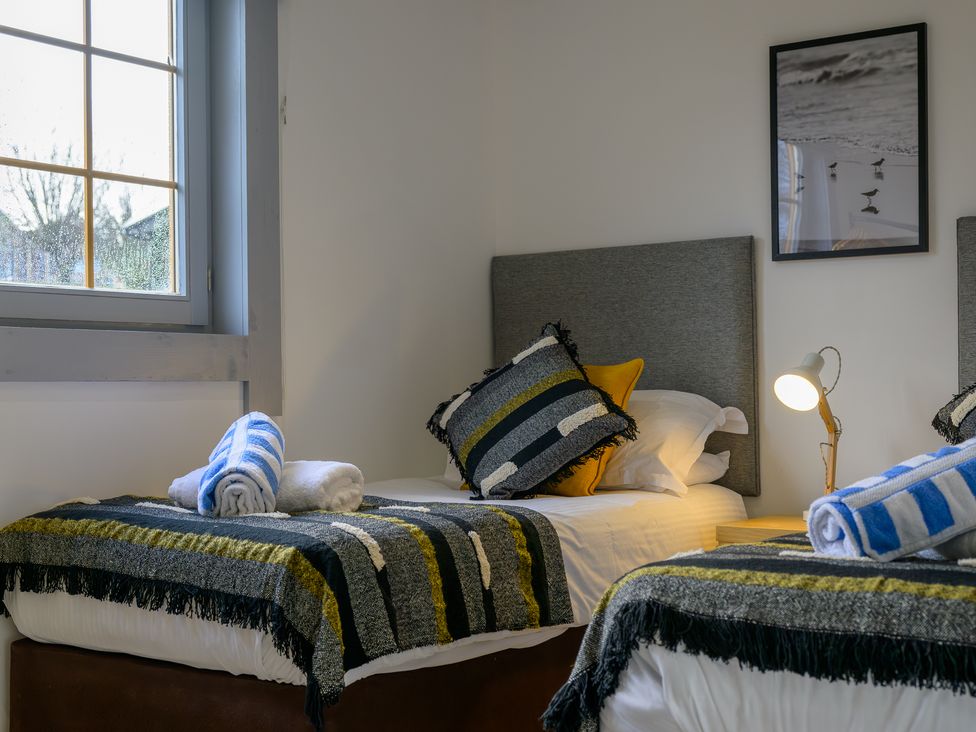 A bedroom with two beds and a lamp at Senara Hot Tub Lodge (Pet) Portreath