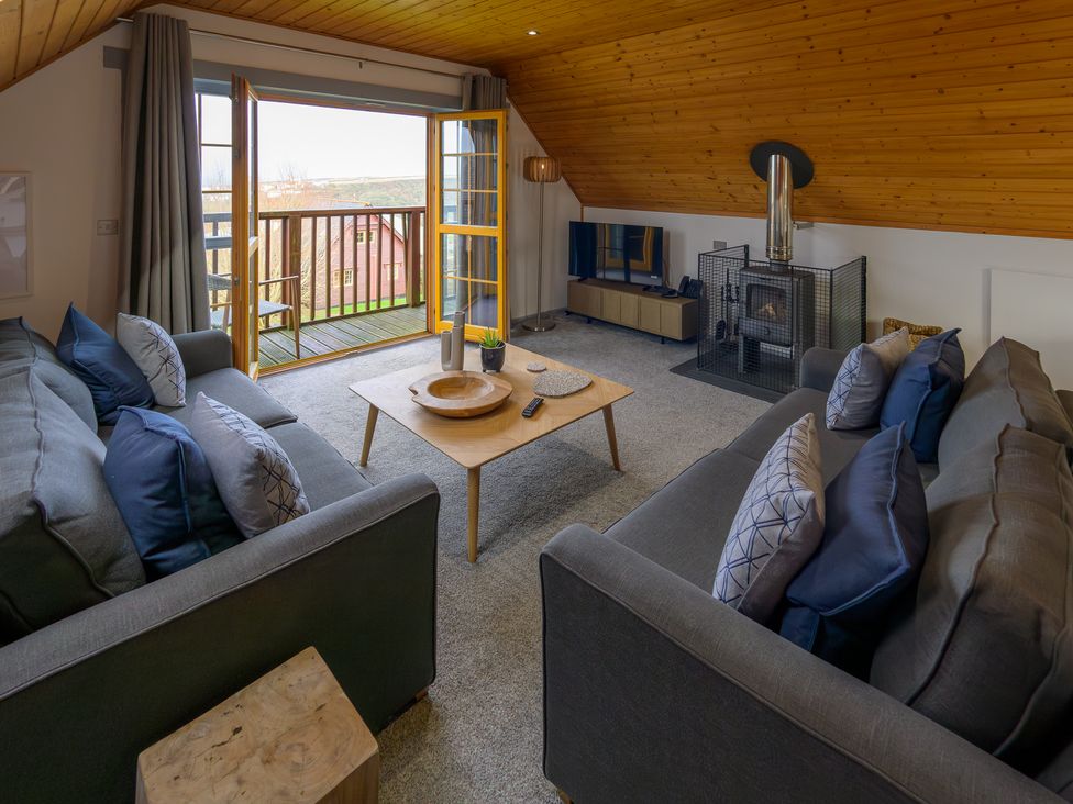 A living room with a sofa and table at Senara Hot Tub Lodge (Pet) Portreath