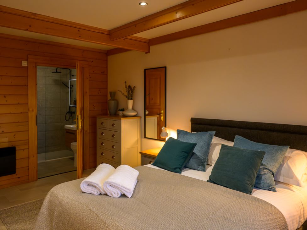 A bedroom with a bed and dresser at Senara Hot Tub Lodge (Pet) Portreath
