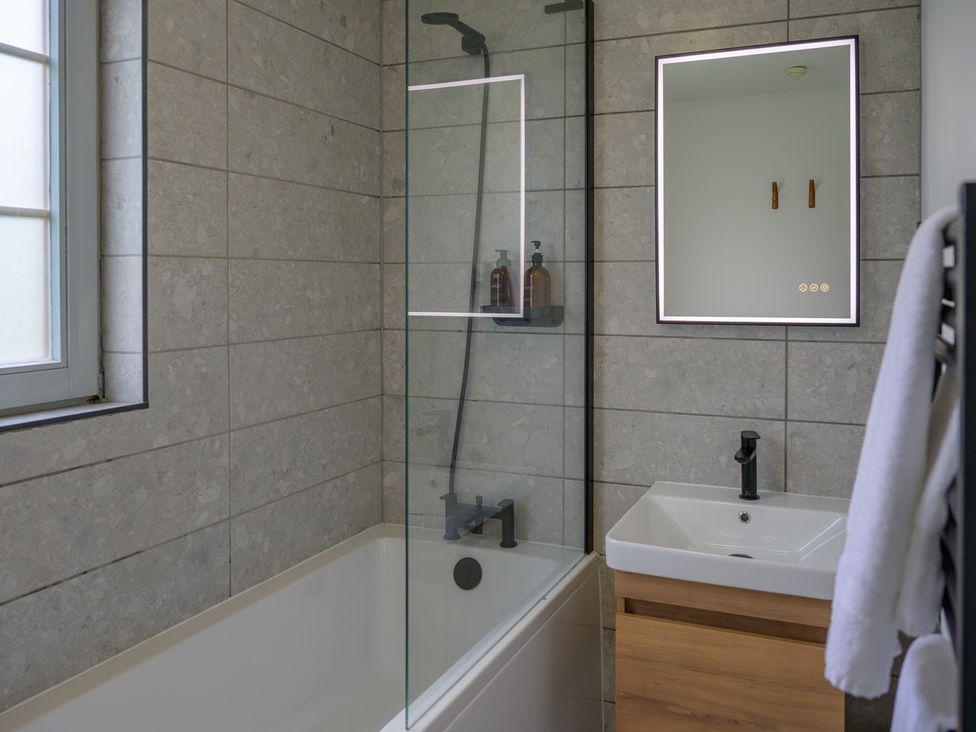 A bathroom with a bathtub, shower, sink, and mirror at Senara Hot Tub Lodge (Pet) Portreath