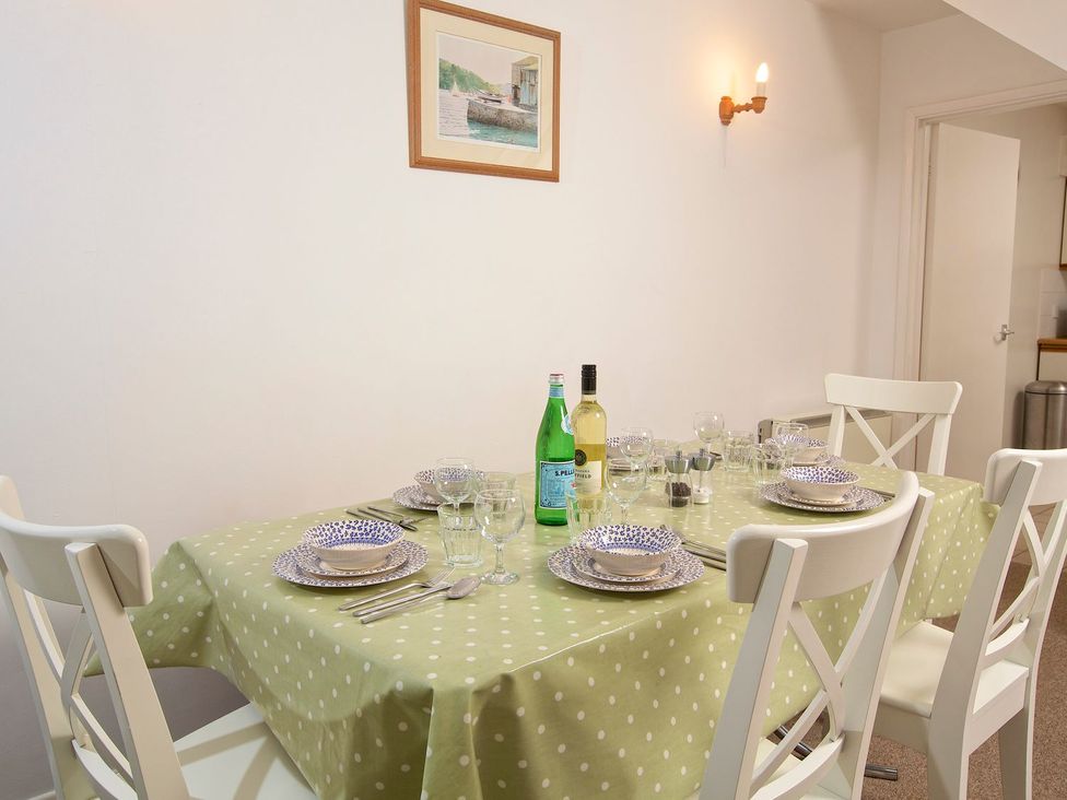 A dining room with a table set for meals at 3 Moult Farm Cottages in Salcombe