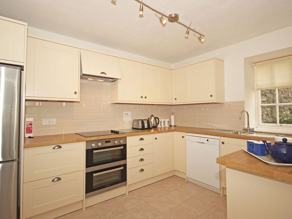 A kitchen with cabinets, stove, sink and appliances at 3 Moult Farm Cottages Salcombe