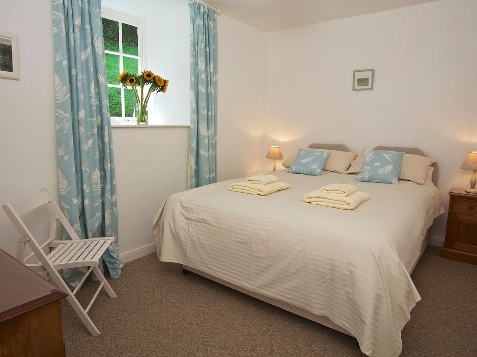 A bedroom with a bed and window at 3 Moult Farm Cottages Salcombe