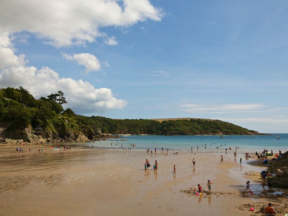 A beach with people enjoying the water at 3 Moult Farm Cottages in Salcombe