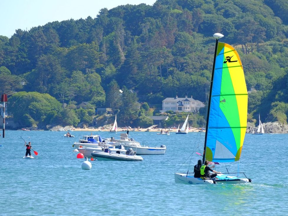 A sailboat and motorboats in water at 3 Moult Farm Cottages Salcombe