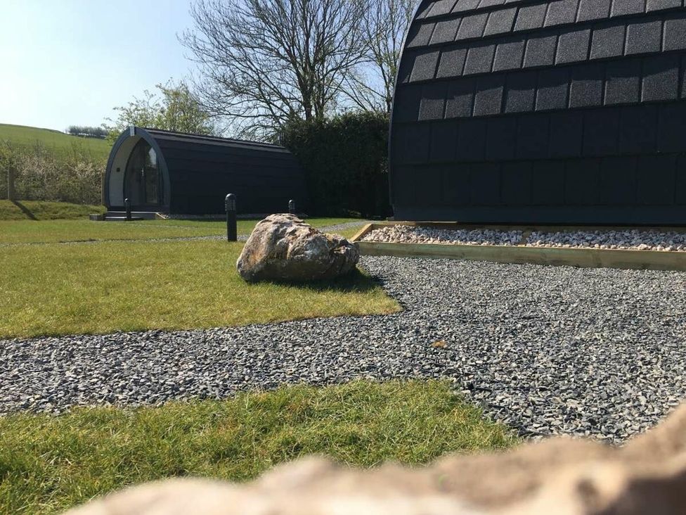 An outdoor area with a gravel pathway and a building at Pod 4 (No Pets) in Carnforth